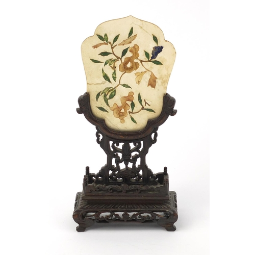 642 - Oriental Chinese jade panel with relief floral decoration, raised on a carved hardwood stand, 20cm h... 