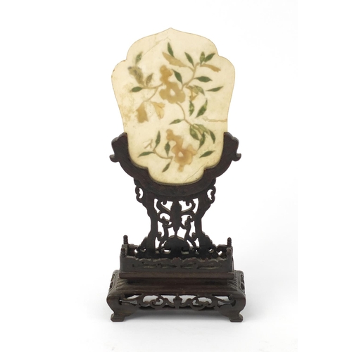 642 - Oriental Chinese jade panel with relief floral decoration, raised on a carved hardwood stand, 20cm h... 