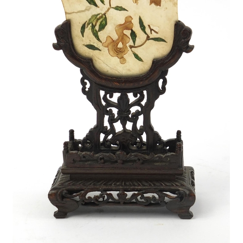 642 - Oriental Chinese jade panel with relief floral decoration, raised on a carved hardwood stand, 20cm h... 