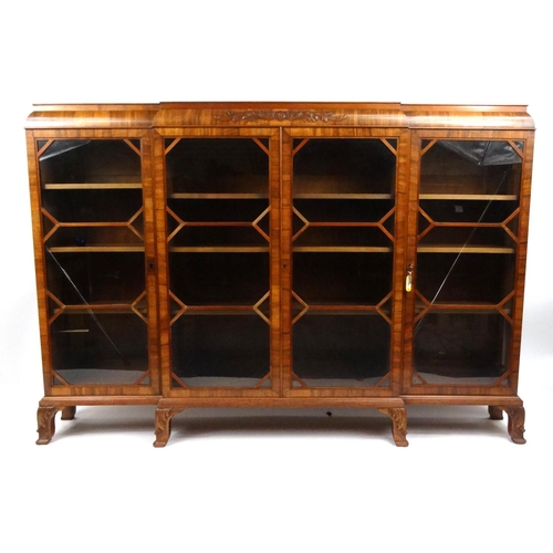 8 - Walnut breakfront bookcase with relief moulded decoration, 127cm high x 184cm wide x 33cm deep