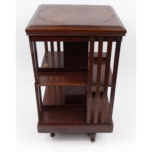 70 - Square mahogany revolving bookcase, the top with engraved script, 84cm high x 49cm square
