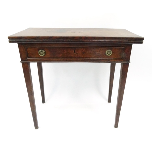 11 - Early 19th century oak tea table with folding top above a drawer on tapering legs, 74cm high x 67cm ... 