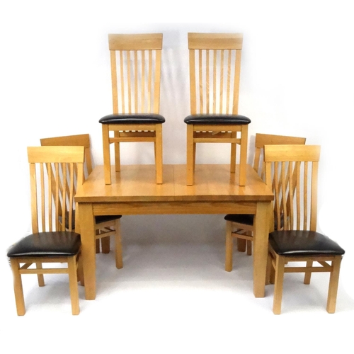 32 - Light oak extending dining table with two extra leaves and six curved slatback chairs, the table 92c... 
