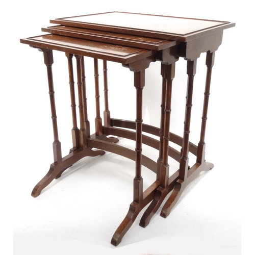 23 - Nest of three mahogany occasional tables on simulated bamboo legs, the largest 58cm high