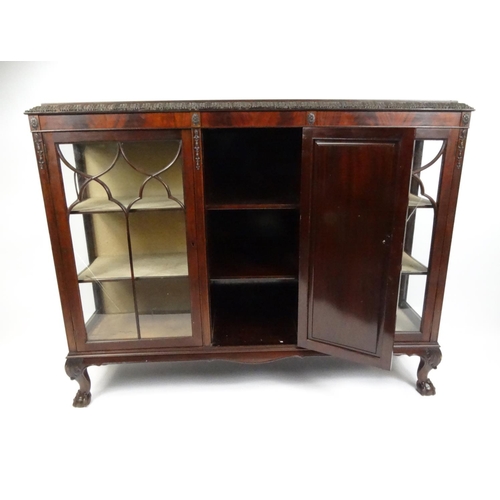 26 - Glazed mahogany bookcase fitted with a central cupboard door raised on ball and claw feet, 117cm hig... 