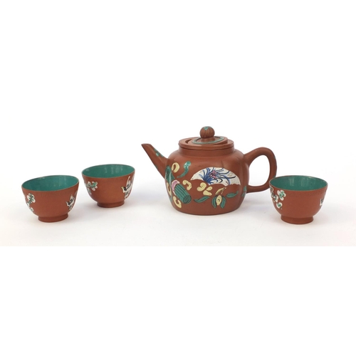 588 - Oriental Chinese Yixing pottery teapot hand enamelled with a panel of flowers and objects, character... 