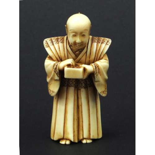 612 - Oriental Japanese ivory Netsuke of a robed elder holding a pot, with moveable head, 5cm high