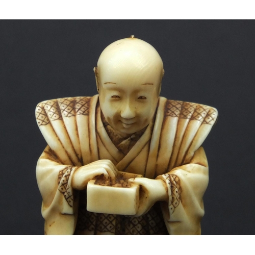 612 - Oriental Japanese ivory Netsuke of a robed elder holding a pot, with moveable head, 5cm high