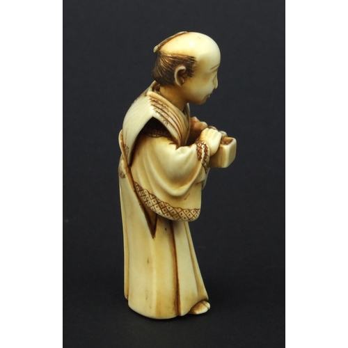 612 - Oriental Japanese ivory Netsuke of a robed elder holding a pot, with moveable head, 5cm high