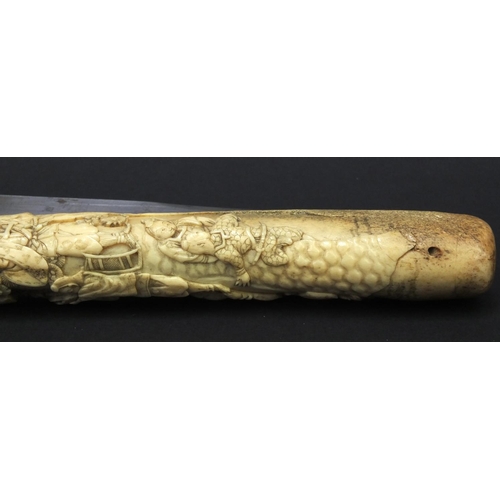 623 - Oriental carved bone dagger profusely carved with robed figures climbing a tree, 27.5cm long