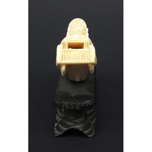 615 - Oriental carved ivory model of a junk, the roof carved with flowers, raised on a wooden base, 5.5cm ... 