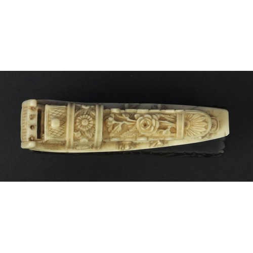 615 - Oriental carved ivory model of a junk, the roof carved with flowers, raised on a wooden base, 5.5cm ... 