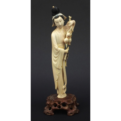 604 - Oriental ivory carved okimono of a girl holding flowers and wearing a robe, raised on a hardwood bas... 