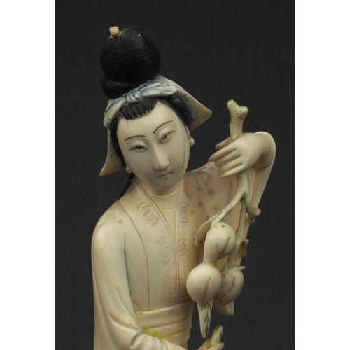 604 - Oriental ivory carved okimono of a girl holding flowers and wearing a robe, raised on a hardwood bas... 