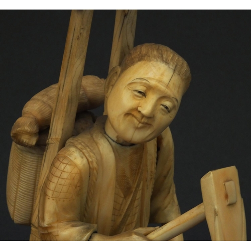 601 - Oriental ivory okimono of a peasant carrying a basket and tools, 23cm high