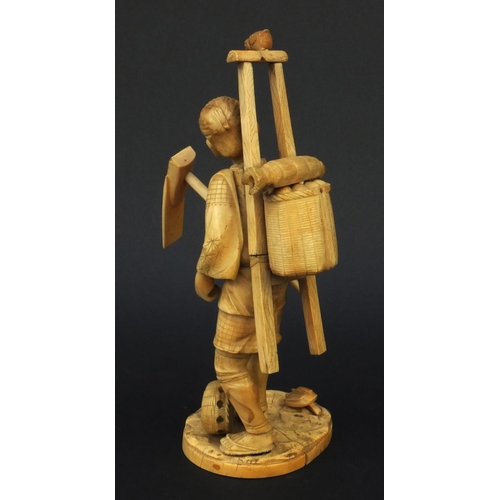 601 - Oriental ivory okimono of a peasant carrying a basket and tools, 23cm high