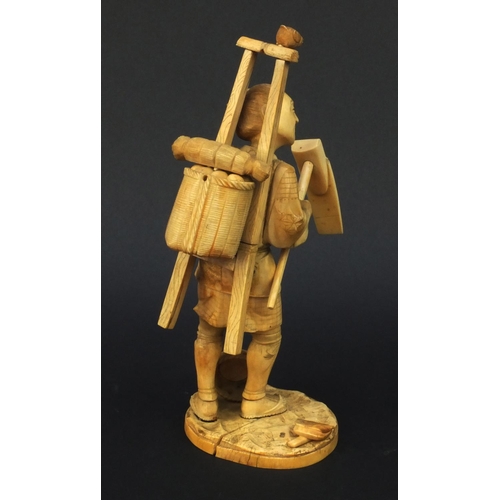 601 - Oriental ivory okimono of a peasant carrying a basket and tools, 23cm high