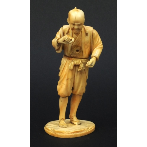 609 - Oriental Japanese carved ivory okimono of a tradesman, red seal mark to base, 15cms high