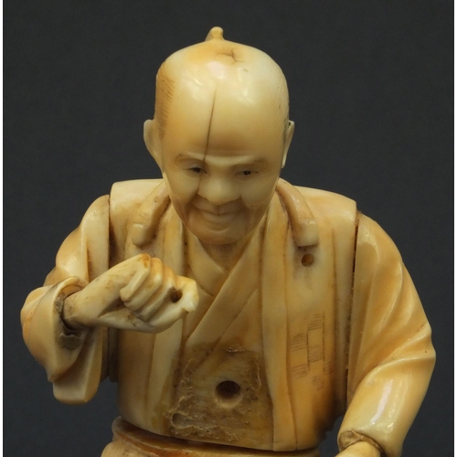 609 - Oriental Japanese carved ivory okimono of a tradesman, red seal mark to base, 15cms high