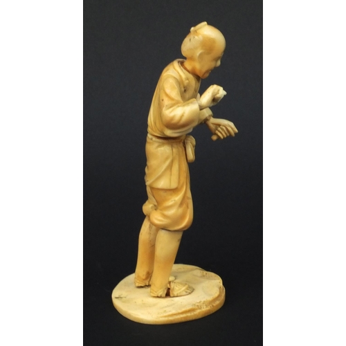 609 - Oriental Japanese carved ivory okimono of a tradesman, red seal mark to base, 15cms high