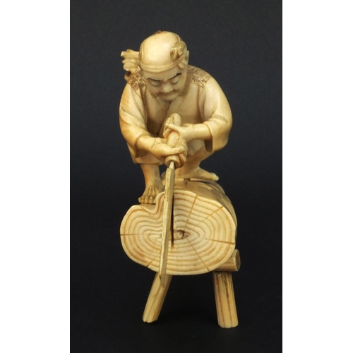 599 - Oriental Japanese carved ivory okimono of an elder and child standing on a tree trunk, the elder cut... 