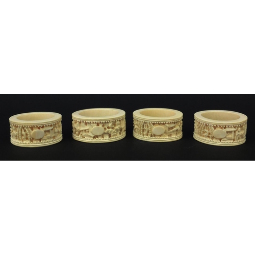 626 - Four oriental Chinese Canton ivory napkin rings carved with figures, each 6.5cm diameter