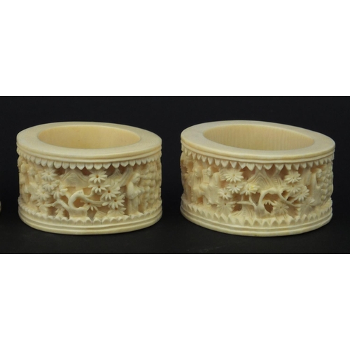 626 - Four oriental Chinese Canton ivory napkin rings carved with figures, each 6.5cm diameter