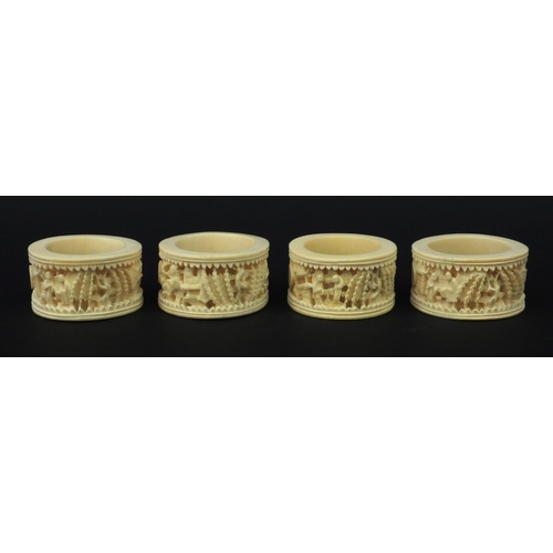 626 - Four oriental Chinese Canton ivory napkin rings carved with figures, each 6.5cm diameter