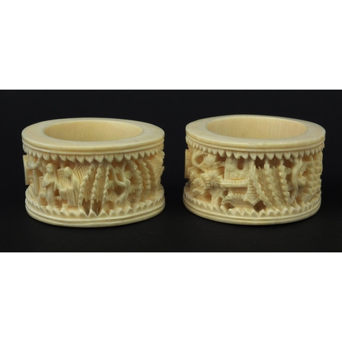 626 - Four oriental Chinese Canton ivory napkin rings carved with figures, each 6.5cm diameter