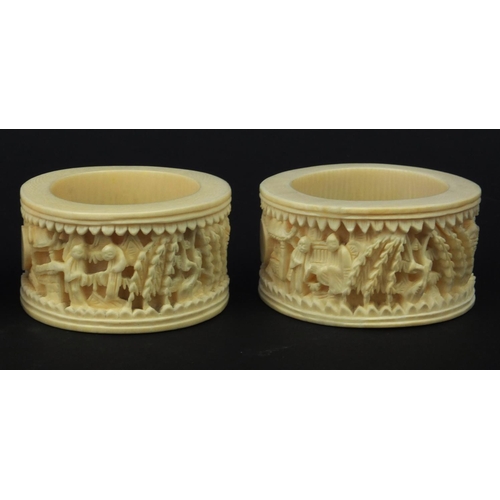 626 - Four oriental Chinese Canton ivory napkin rings carved with figures, each 6.5cm diameter