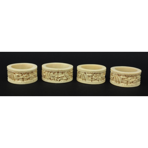 626 - Four oriental Chinese Canton ivory napkin rings carved with figures, each 6.5cm diameter