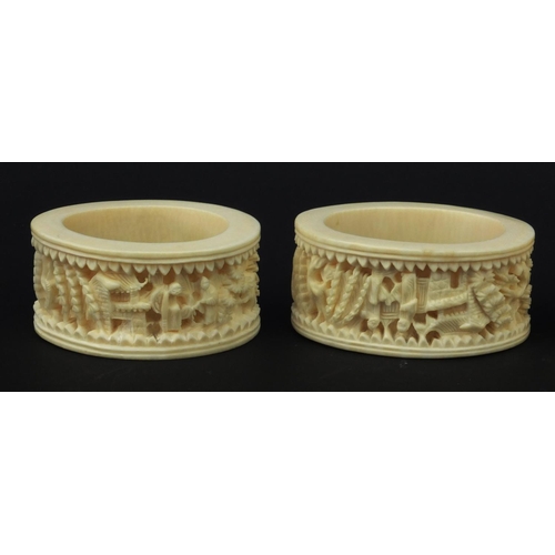 626 - Four oriental Chinese Canton ivory napkin rings carved with figures, each 6.5cm diameter