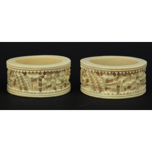 626 - Four oriental Chinese Canton ivory napkin rings carved with figures, each 6.5cm diameter