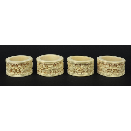 626 - Four oriental Chinese Canton ivory napkin rings carved with figures, each 6.5cm diameter