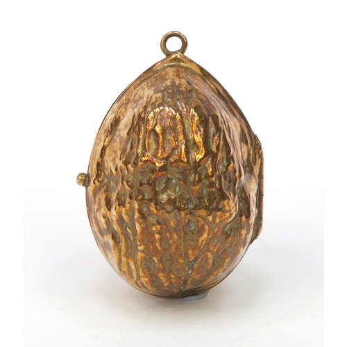 100 - Lady's pendant brass compact in the form of a nut with mirrored interior, 4cm wide