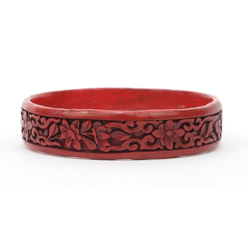 651 - Oriental Chinese cinnabar lacquer bangle carved with flowers, 7cm diameter