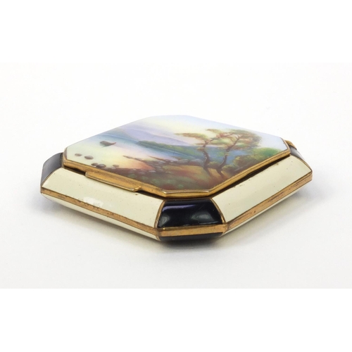 115 - Gilt metal enamelled compact, the lid enamelled with a lake and mountain, 5.5cm wide