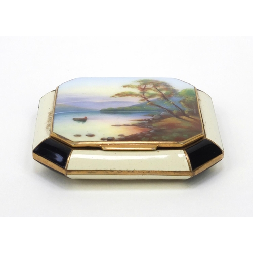 115 - Gilt metal enamelled compact, the lid enamelled with a lake and mountain, 5.5cm wide