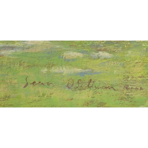 1269 - Unframed oil onto board of a landscape view with a cottage in the distance, bearing a signature Sean... 