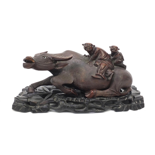 653 - Large oriental Chinese carved hardwood water buffalo with figures,  mounted on a carved hardwood sta... 