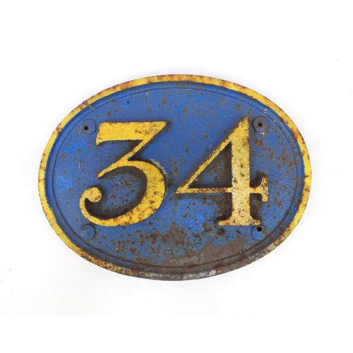 192 - Railway interest painted cast iron oval sign '34', 39cm wide