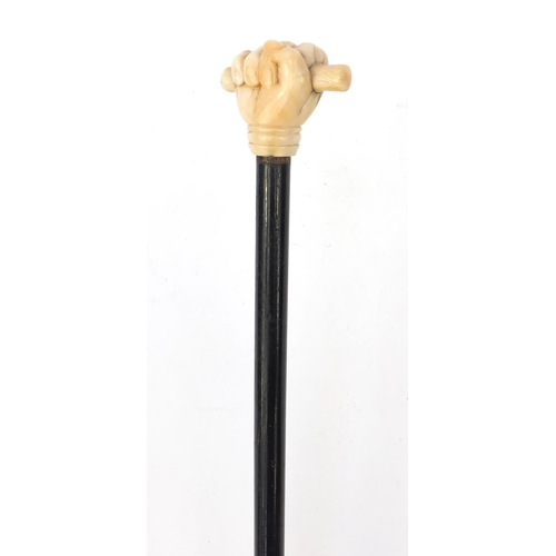 66 - Ebonised walking stick with ivory pommel carved as a clenched fist, 90cm long