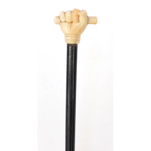 66 - Ebonised walking stick with ivory pommel carved as a clenched fist, 90cm long