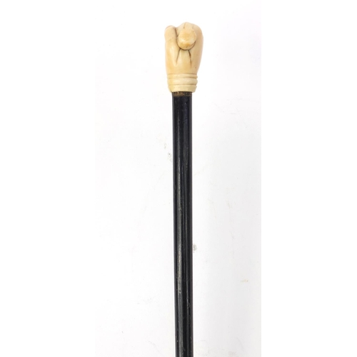 66 - Ebonised walking stick with ivory pommel carved as a clenched fist, 90cm long