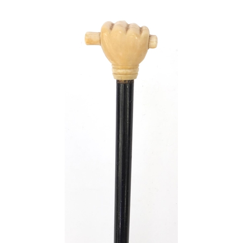 66 - Ebonised walking stick with ivory pommel carved as a clenched fist, 90cm long