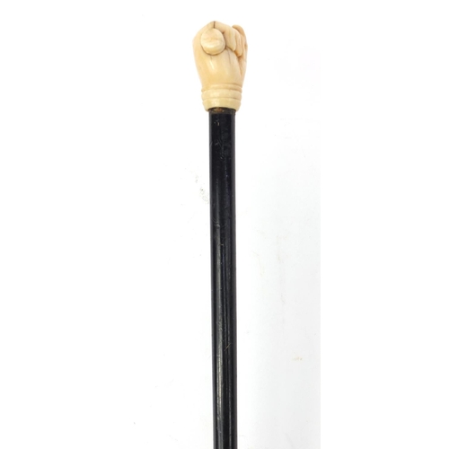 66 - Ebonised walking stick with ivory pommel carved as a clenched fist, 90cm long