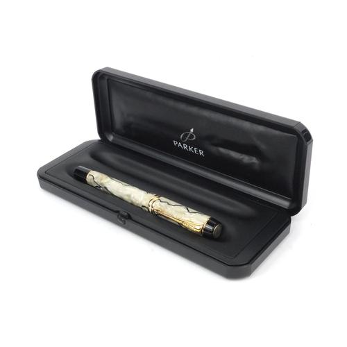 134 - Boxed Parker Duofold cream and black marbleised fountain pen with 18ct gold nib, the pen 14cm long