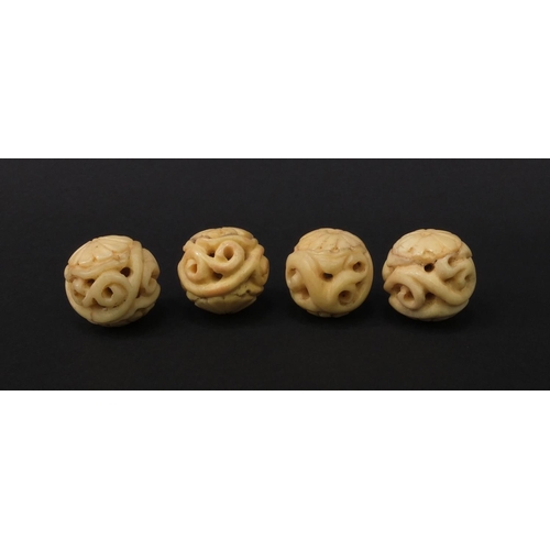 98 - Four carved ivory beads, each 2.3cm diameter