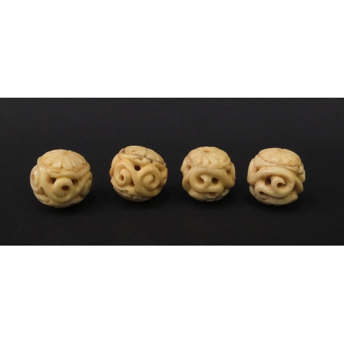 98 - Four carved ivory beads, each 2.3cm diameter