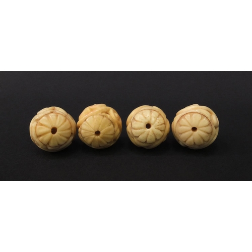 98 - Four carved ivory beads, each 2.3cm diameter